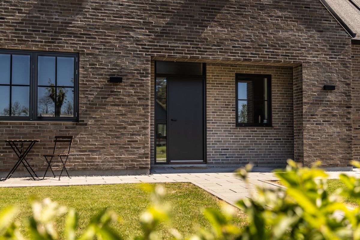 Facade på nybyggeri bolig med pladedør med sideparti og overparti